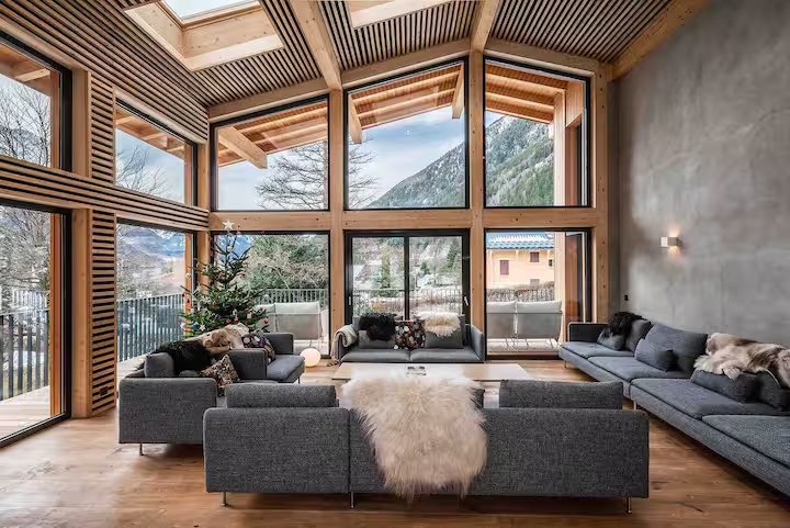 Інтерʼєр шале: салон з каміном, вікна у гори